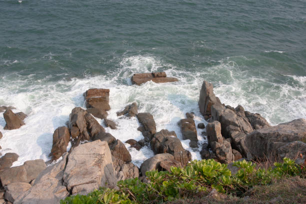 istock 20 Oct 2007 sea wave crashing on rock coast with spray, hk 1291858965