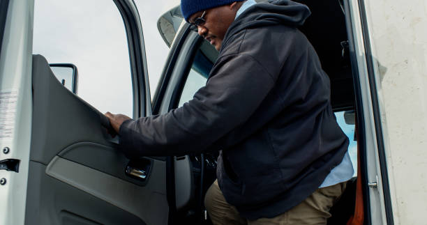 istock Truck Driver Getting Out of Cab and Smiling for Camera 1291862034