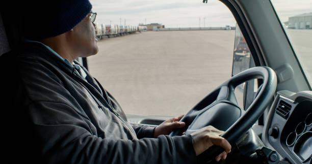 istock Truck Driver Looking Out Into Yard 1291862042
