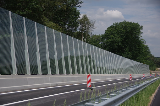 New installed glass noise barrier near the highway