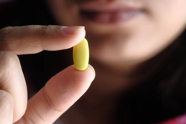 istock young women hand holding pill close up 1291863767