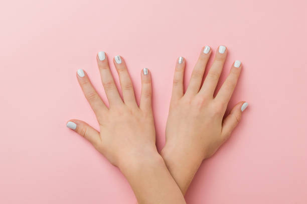 istock Hands lying on top of each other with stylish makeup on a pink background. 1291866732