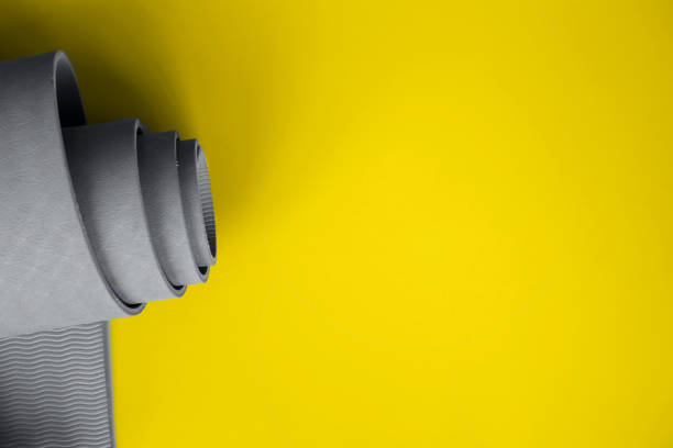 istock Ultimate gray yoga mat on a illuminating background 1291872236