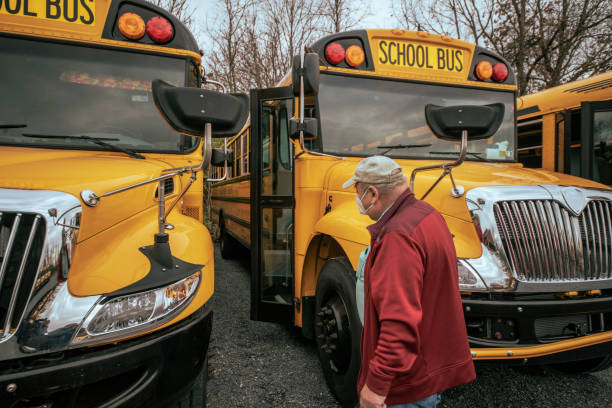 istock Senior man, the bus driver, inspecting the school bus before a ride. 1291873625