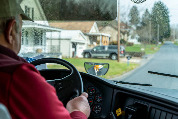 istock Senior man, the bus driver, driving a school bus. 1291873657