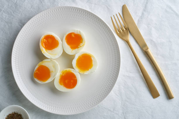 istock Soft-boiled eggs, peeled and cut into two halves, lying on white plate 1291878560