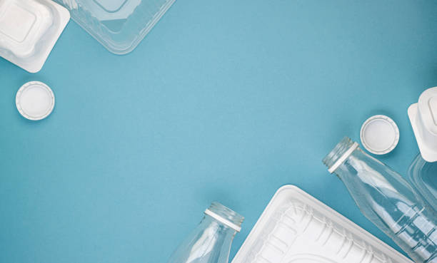 istock Empty plastic bottles with white lids, packages and dishes in a pile on a blue background 1291880479