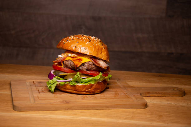 istock Tasty hamburger on wooden table 1291884055