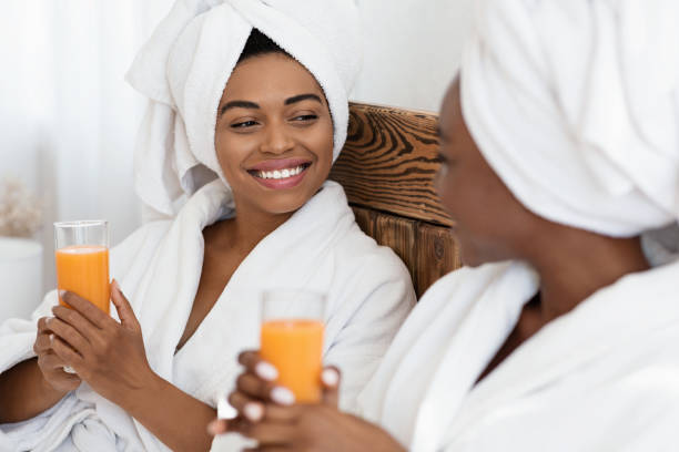 istock Two beautiful black women drinking fresh juice in bed 1291889459