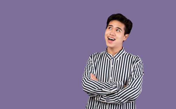 istock Portrait of smiling asian man looking up at studio 1291889475