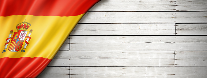 Spain flag on old white wall. Horizontal panoramic banner.