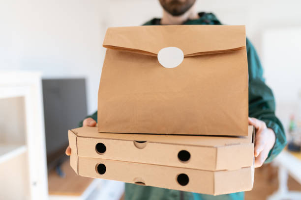 istock Holding pizza boxes with paper bag on top 1291890642