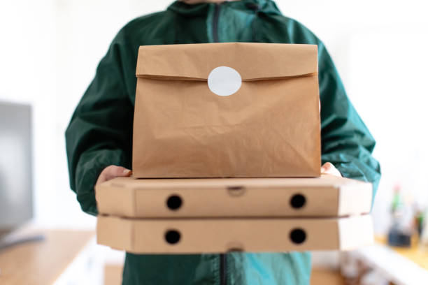 istock Delivering pizza boxes and paper bag on top 1291890645