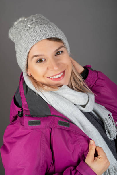 istock Woman with winter outfit on grey background 1291894986