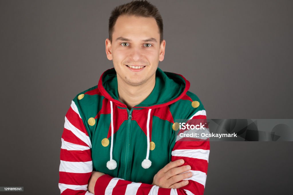 Handsome Grinch on grey background Portrait of handsome man wearing Grinch costume is smiling to the camera on grey background Adult Stock Photo