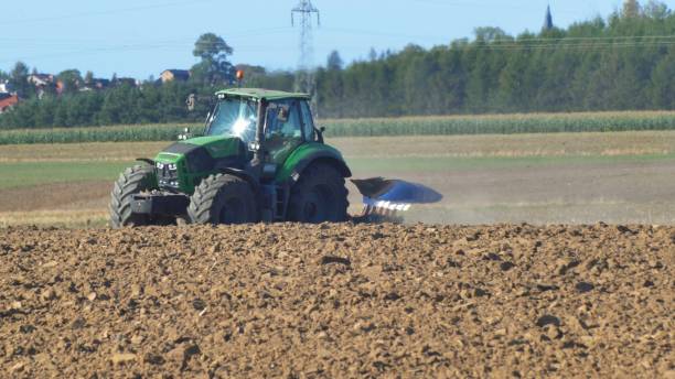 istock Farmer Ploughing Soil using Tractor with Mouldboard Plough on Sunny Day 1291895722