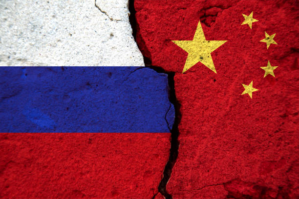 istock Russia and China flags on a crack in the wall between them. Broken relationships between countries concept. 1291895745