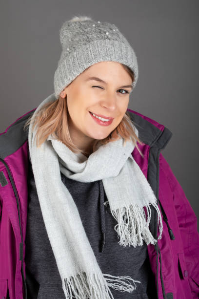 istock Woman with winter outfit on grey background 1291895790