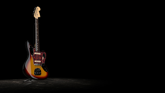 Front of electric guitar body on dark background.
