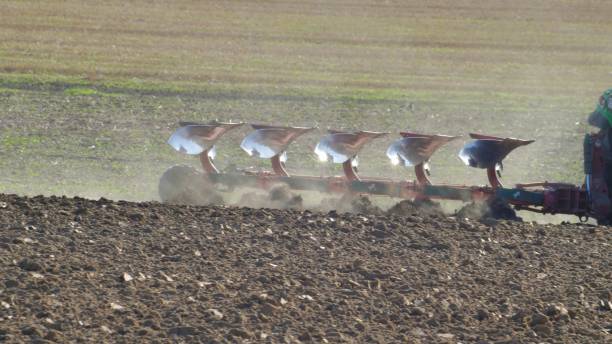 istock Farmer Ploughing Soil using Tractor with Mouldboard Plough on Sunny Day 1291896426