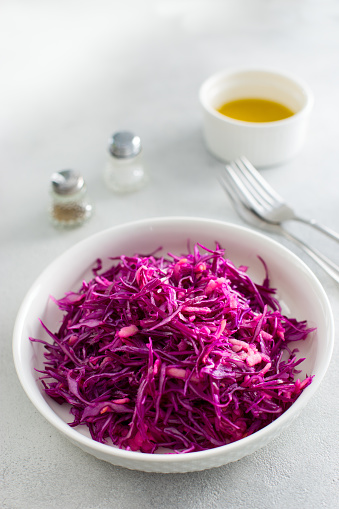 fresh red cabbage salad with apple on white plate, selective focus