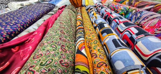 istock Rolls of fabrics with various very colorful and fanciful patterns on a market. 1291898839