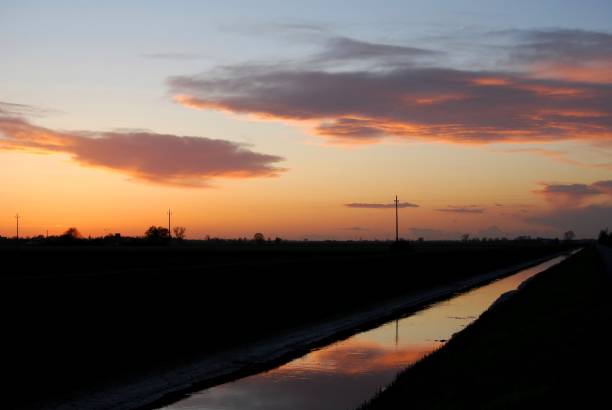 istock sunset in the countryside with reflection on a canal 1291901284