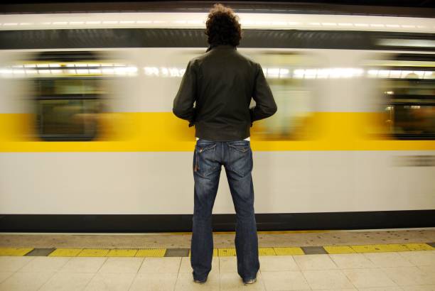 young man from behind waiting for the subway stock photo
