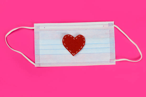 istock disposable medical mask with heart. Protection from coronavirus, self-defence 1291902327