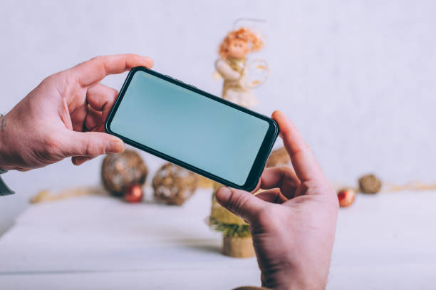 istock Mockup technology. The guy holds a smartphone in his hands on a festive background. 1291902901