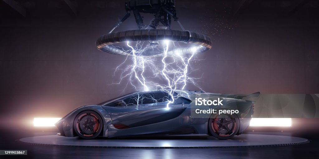 Electric Sports Car Struck By Electrical Lightning From Coil Side view of a generic blue-grey sports car with orange highlights parked on a turntable in an industrial building under a large  coil, from which multiple strikes of electrical lightning are emanating, striking the bodywork of the vehicle. The has lights behind it, and a thin haze. Sports Car Stock Photo