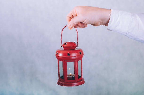 istock A man holds a lamp with a candle in his hands on a white background. 1291903934