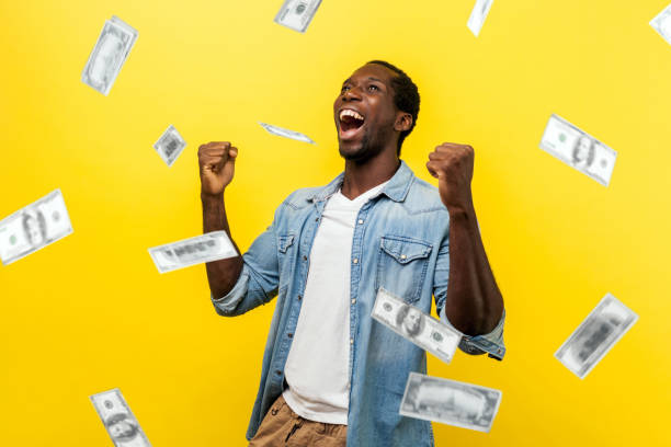 lluvia de dinero, ganador y rico. joven excitado joven hombre motivado de pie con los puños levantados y gritando de alegría, ganador emocionado por el éxito. - super powers fotografías e imágenes de stock