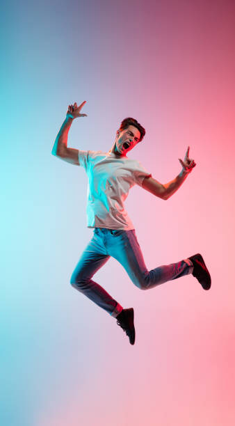 istock Young caucasian man's portrait on gradient blue-pink studio background in neon light 1291915513