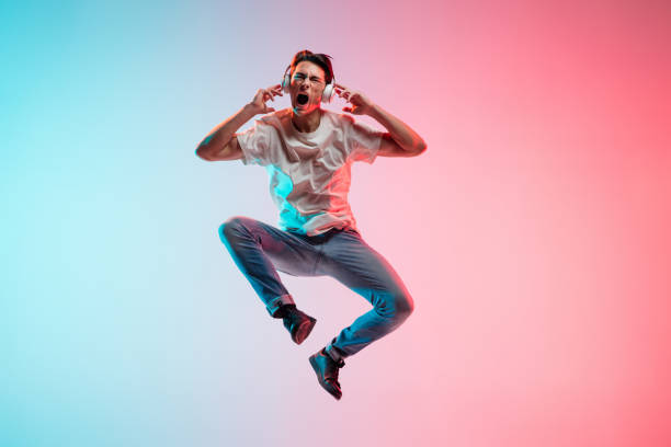 istock Young caucasian man's portrait on gradient blue-pink studio background in neon light 1291915543