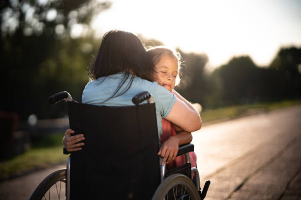 barn whit ögon slutna omfamna sin mamma i rullstol - paraplegisk bildbanksfoton och bilder