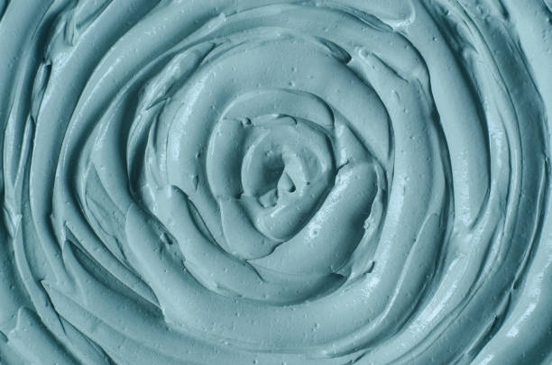 istock Gray bentonite facial clay (mask, face cream, body wrap) texture close up, selective focus. Abstract background with circle brush strokes. 1291917644