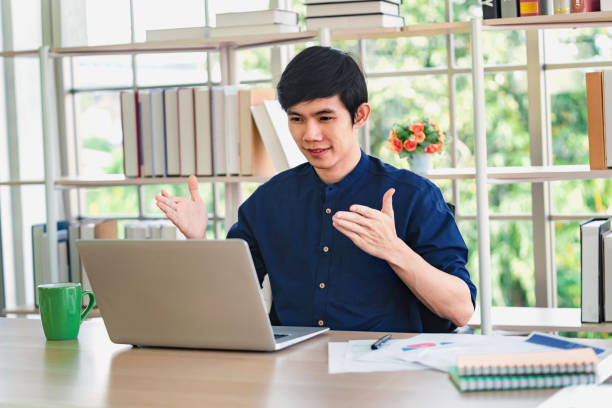 istock asian man video call with laptop in office 1291920636