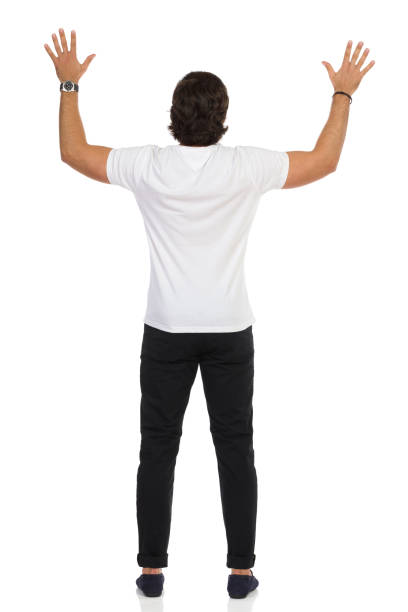 istock Rear View Of Man Standing With Hands Raised. 1291921825