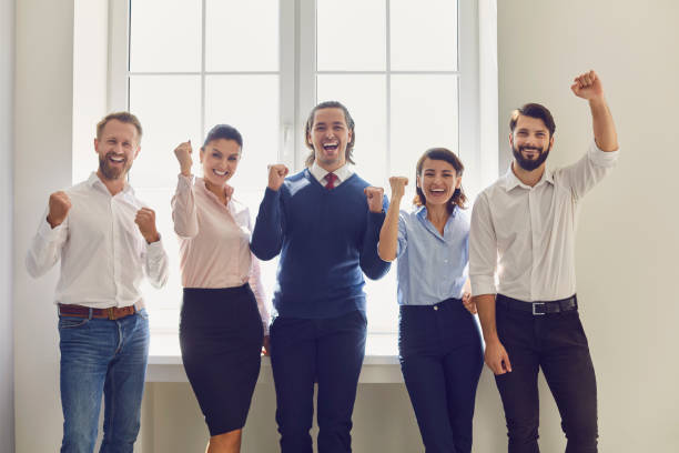 istock Group of smiling business people expressing successful teamwork or project realization in office 1291921841
