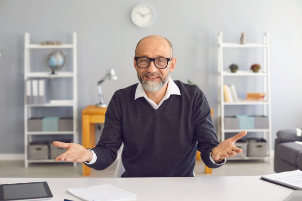 istock Happy senior teacher talking interview video call looking at camera online course at home. 1291923938