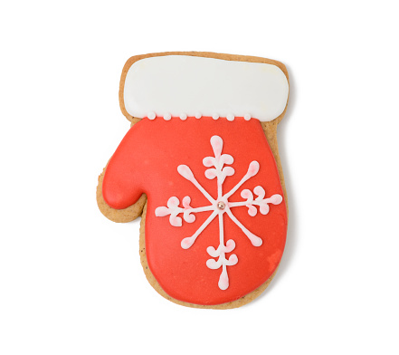 mitten shaped baked christmas cookies with red sugar icing isolated on white background, close up