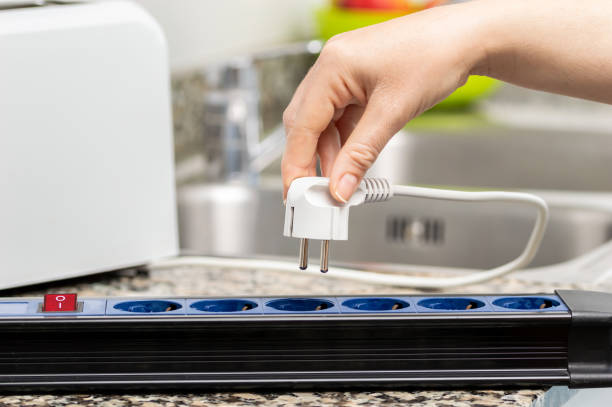 woman plugging a toaster into the electrical outlet