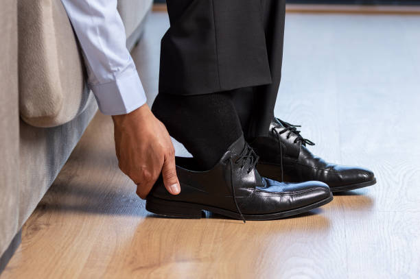 uomo d'affari togliersi le scarpe - exhaustion tired men after work foto e immagini stock