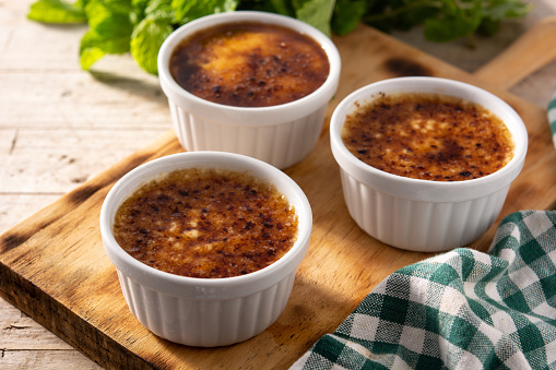 Homemade creme brulee in bowl on wooden table