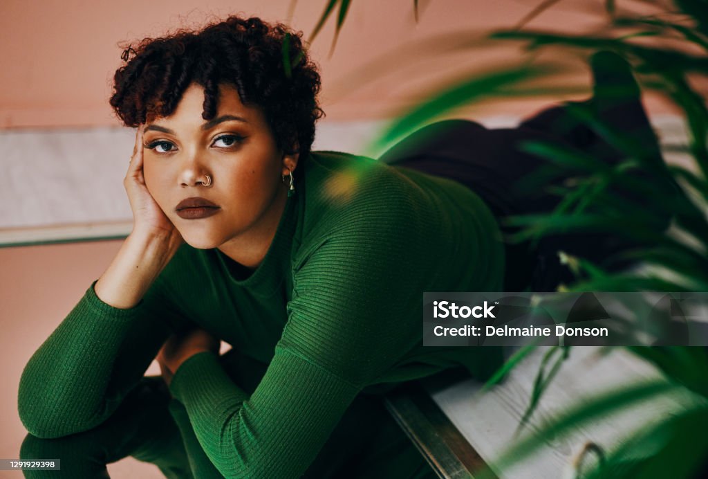 There's nothing more beautiful than a woman who's unafraid to be herself Cropped shot of a beautiful young woman lying on the floor Fashion Stock Photo