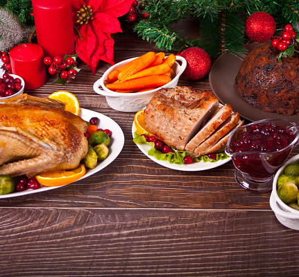Table served for thanksgiving or Christmas dinner. Stuffed roasted turkey and glazed ham. Traditional celebrating holiday. Copy space.