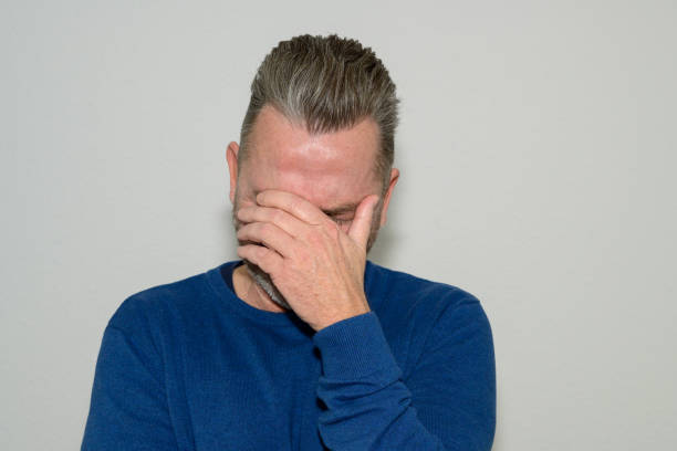 istock Despondent man holding his head in his hand 1291935790