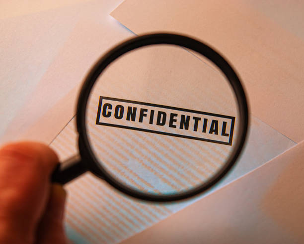 istock hand holds a magnifying glass over the inscription confidential 1291937069