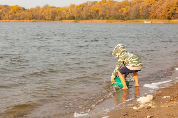 istock Boy Playing in Lake on Autumn Morning 1291937206